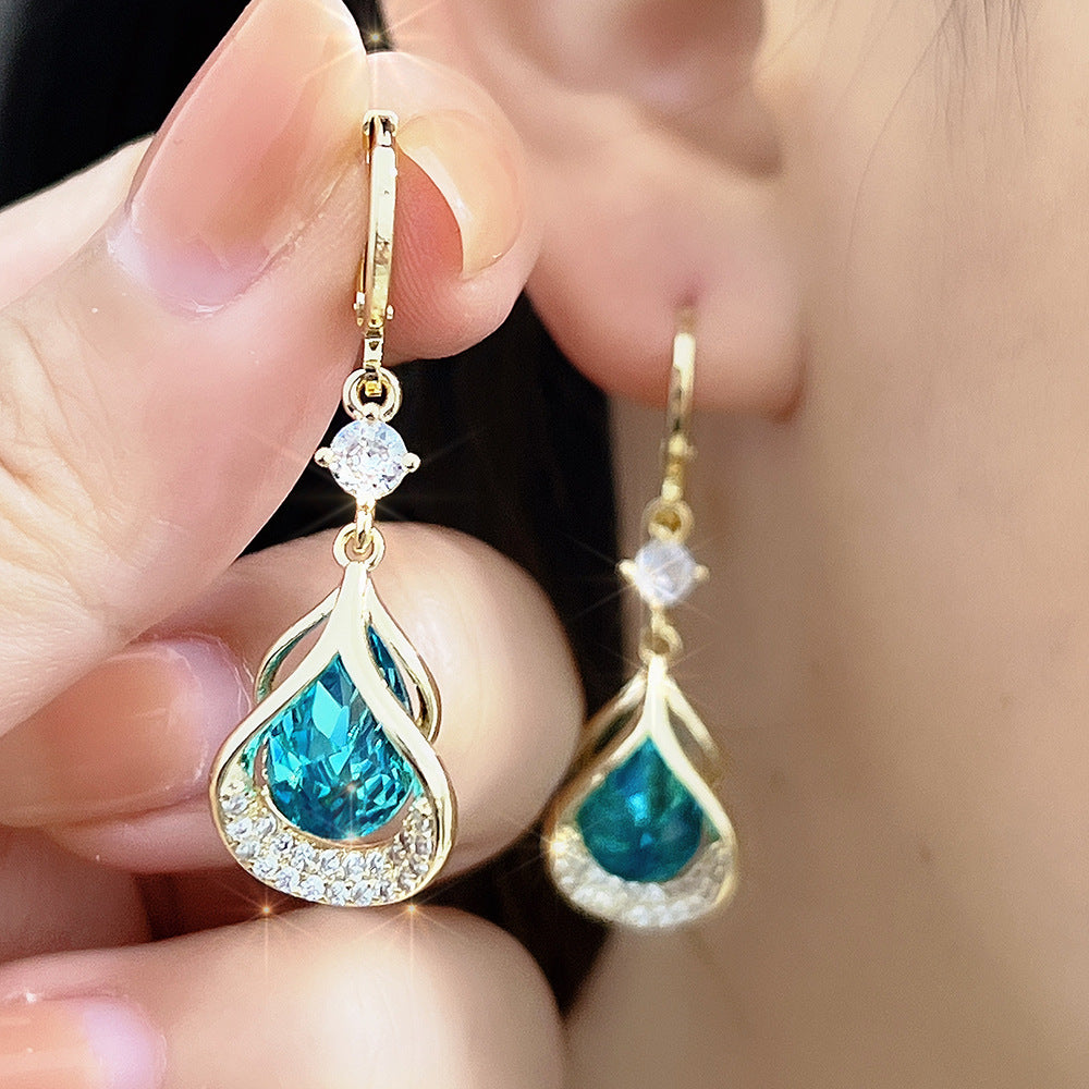 Three pairs of WIMAID™ Lymph Flow Magnetogen Earrings in white, blue, and purple with magnetic accents, displayed in a set.