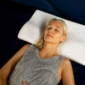 White cervical pillow from Aurenza Shop designed for neck support and relief from discomfort.