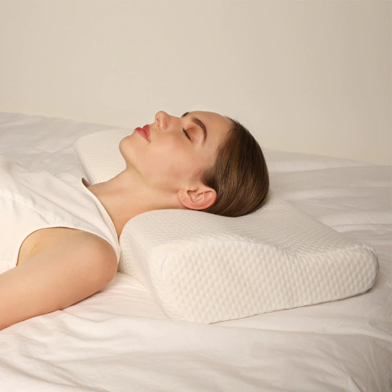 White cervical pillow from Aurenza Shop designed for neck support and relief from discomfort.