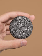 Gray Reverse Bar shampoo bar by Aurenza Shop, shown in a natural setting with its sleek gray packaging and product details.